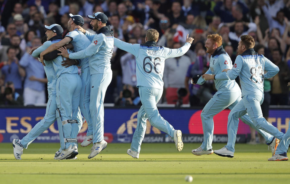 England players mob Jofra Archer after he bowled the super over to win the Cricket World Cup final match between England and New Zealand at Lord's cricket ground in London, Sunday, July 14, 2019. England won after a super over after the scores ended tied after 50 overs each. (AP Photo/Matt Dunham)
