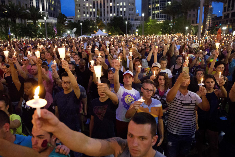 FILE - Crowd members hold up candles during a vigil downtown for the victims of a mass shooting at the Pulse nightclub Monday, June 13, 2016, in Orlando, Fla. (AP Photo/David Goldman, File)