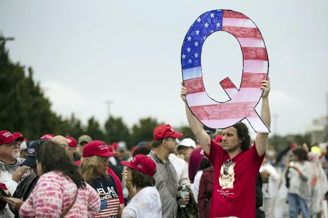 <span class="caption">A protester holds a Q sign as he waits to enter a campaign rally with then-President Donald Trump in Wilkes-Barre, Pa., in August 2018.</span> <span class="attribution"><a class="link " href="https://newsroom.ap.org/detail/QAnonEventVegas/a4e2c53c530b45b8b3a6b1bce25ba084/photo?Query=qanon&mediaType=photo&sortBy=arrivaldatetime:desc&dateRange=Anytime&totalCount=107&currentItemNo=31" rel="nofollow noopener" target="_blank" data-ylk="slk:AP Photo/Matt Rourke;elm:context_link;itc:0;sec:content-canvas">AP Photo/Matt Rourke</a></span>