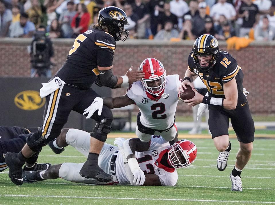 Oct 1, 2022; Columbia, Missouri; Missouri Tigers quarterback Brady Cook (12) runs as Georgia Bulldogs linebacker Smael Mondon Jr. (2) attempts to make a tackle during the first half at Faurot Field at Memorial Stadium. Mandatory Credit: Denny Medley-USA TODAY Sports