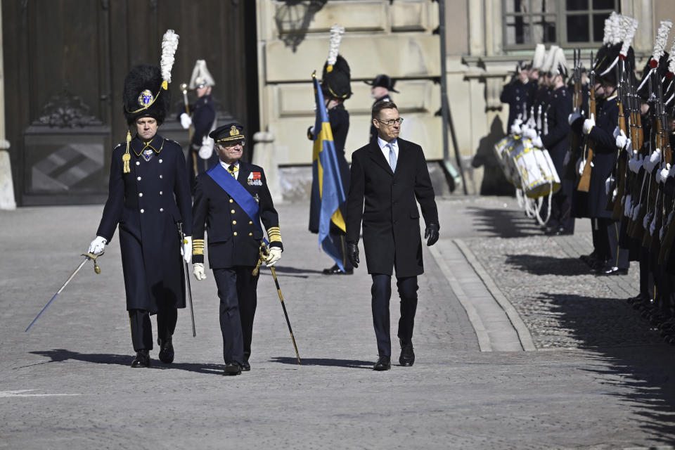 Swedish King Carl Gustaf, left, and President of Finland Alexander Stubb, review the Grenadier Guards of the Life Guards at the Inner courtyard at the Royal Palace in Stockholm on the occasion of Stubb's two-day visit to Sweden, Tuesday, April 23, 2024. (Henrik Montgomery/TT News Agency via AP)