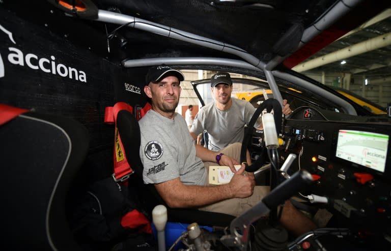 Driver Ariel Jatton (L) and co-driver Gaston Daniel Scazzuso of Argentina pose inside their Acciona Eco Power ahead of the 2016 Dakar Rally on January 1, 2016