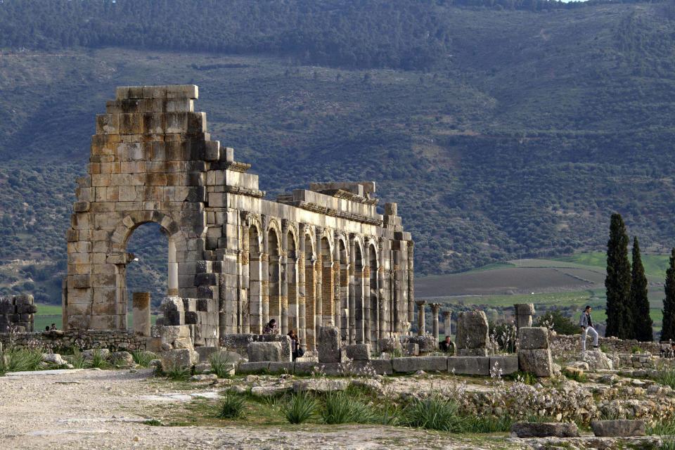In this Thursday, March 8, 2012 photo, the afternoon sun shines on the arches of the Basilica, the main administrative building in the ancient Roman city of Volubilis, near Meknes, Morocco. (AP Photo/Abdeljalil Bounhar)