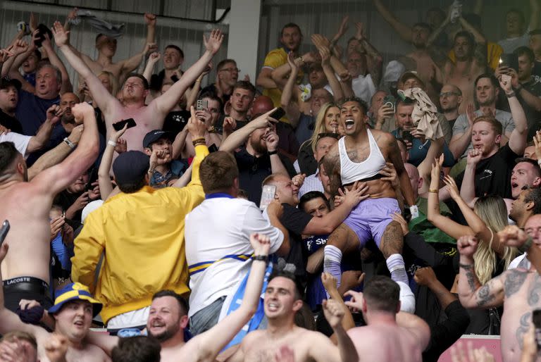 El brasileño Raphinha, figura de Leeds United, celebrando la "supervivencia" del equipo en la Premier League, junto con los hinchas que fueron al estadio de Brentford.