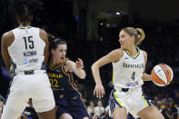 CORRECTS FROM CAITLYN TO CAITLIN - Dallas Wings guard Jacy Sheldon (4) moves the ball as Indiana Fever guard Caitlin Clark (22) is defended by Wings center Teaira McCowan (15), during the second half of an WNBA basketball game in Arlington, Texas, Friday, May 3, 2024. (AP Photo/Michael Ainsworth)