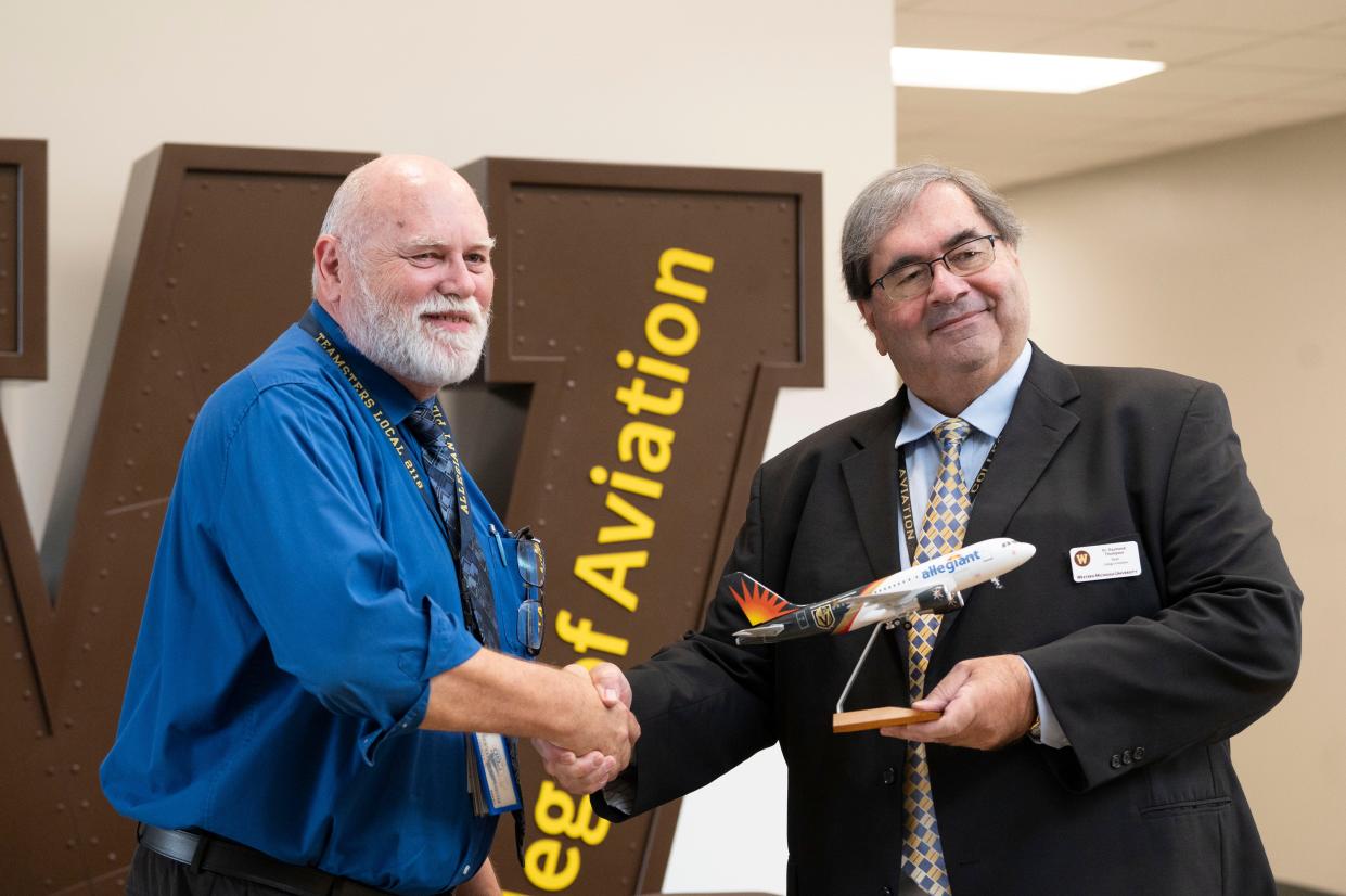 Robert Butler of Allegiant, left, and Raymond Thompson, dean of the Western Michigan University College of Aviation, shake hands after signing an agreement launching the Accelerate Pilot Pathway program Thursday, Nov. 2, 2023 on WMU's aviation campus.