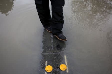 Andrew Culver walks through the flooded waters of the Stillaguamish River, which overtook a roadway in Stanwood, Washington November 18, 2015. REUTERS/David Ryder