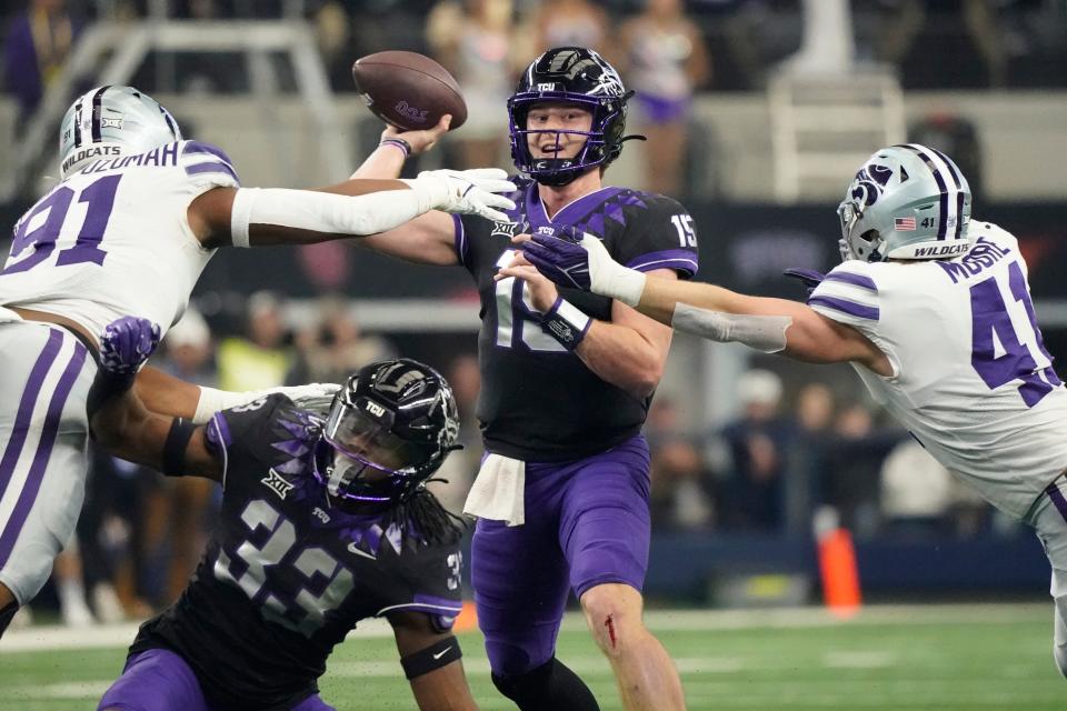 TCU quarterback Max Duggan (15) throws under pressure from Kansas State defensive end Felix Anudike-Uzomah (91) and linebacker Austin Moore (41) in the first half of the Big 12 Conference championship NCAA college football game, Saturday, Dec. 3, 2022, in Arlington, Texas. TCU running back Kendre Miller (33) is at bottom. (AP Photo/LM Otero)