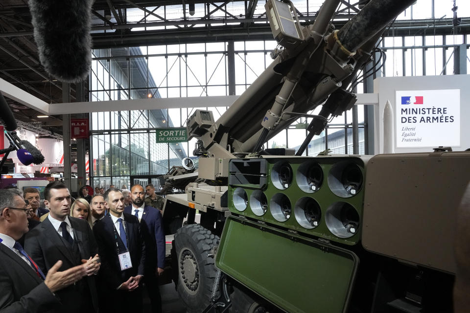 Jordan Bardella, second left, president of the far-right National Front party, looks at a Caesar self-propelled howitzer at the Eurosatory Defense and Security exhibition, Wednesday, June 19, 2024 in Villepinte, north of Paris. Jordan Bardella, hoping to become France's prime minister, appealed Tuesday to voters to hand his party a clear majority after French President Emmanuel Macron's announcement on June 9 that he was dissolving France's National Assembly, parliament's lower house.( AP Photo/Michel Euler)
