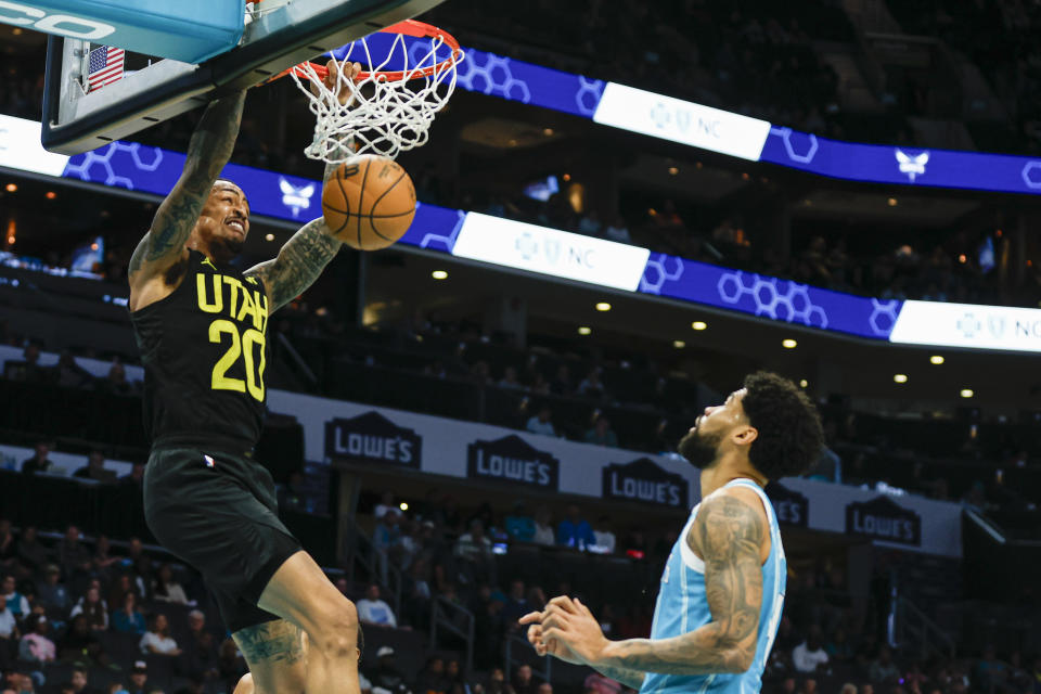 Utah Jazz forward John Collins (20) dunks as Charlotte Hornets center Nick Richards looks on during the first half of an NBA basketball game in Charlotte, N.C., Saturday, Jan. 27, 2024. (AP Photo/Nell Redmond)