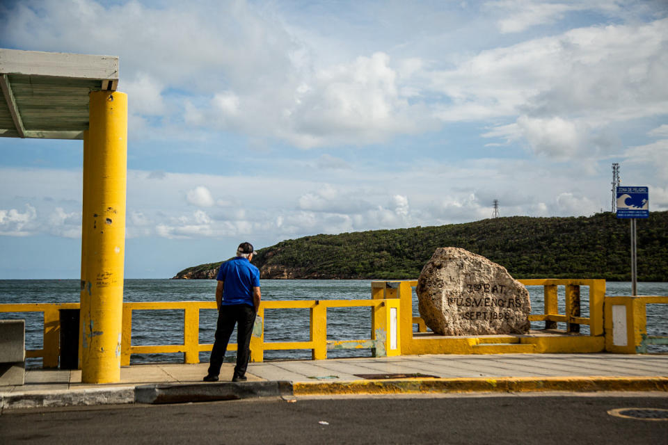 A man stands next to the monument that marks where the U.S. invaded Puerto Rico in 1898 at the Guanica Bay in Guanica on May 29, 2023. (Erika P. Rodríguez for NBC News)