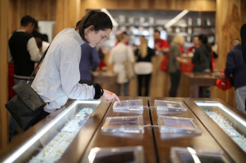 FILE PHOTO: A customer browses screens displaying recreational marijuana products for sale at the MedMen store in West Hollywood