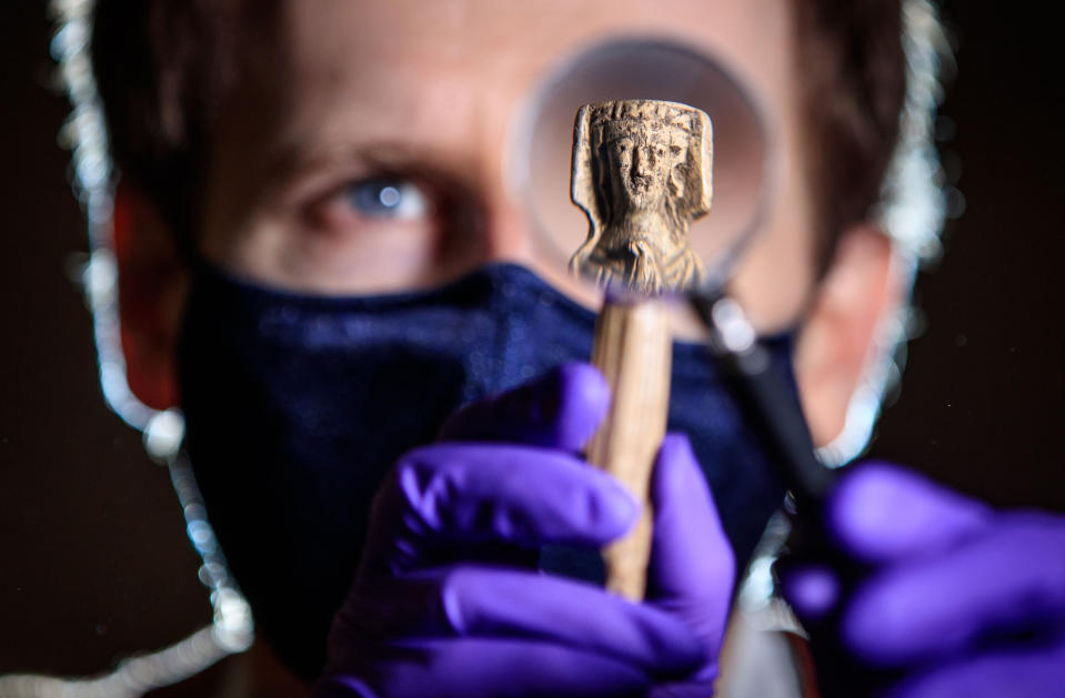 <p>Andrew Woods, senior curator at the Yorkshire Museum, holds a magnifying glass in front of a medieval bone handle carving of a woman dressed in a gown and headdress, dating to the 14th Century, one of thousands of artefacts in the care of York Museums Trust that are being photographed and put online for the public to view, while the museum in York remains closed during England's third national lockdown to curb the spread of coronavirus. Picture date: Wednesday March 10, 2021. (Photo by Danny Lawson/PA Images via Getty Images)</p>
