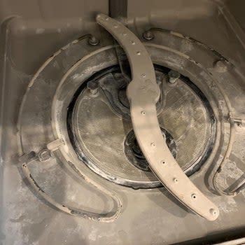 Reviewer photo showing their dishwasher completely covered in grime 