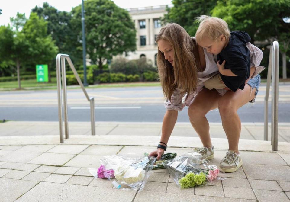 Sarah Hamilton Pfeffer places flowers outside the CMPD Tuesday morning April 30, 2024. Four officers killed and 4 wounded when officers serving a warrant to the suspect in east Charlotte on Monday afternoon.