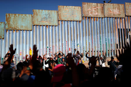 Migrants, part of a caravan of thousands trying to reach the U.S., pray by the border fence between Mexico and the United States, in Tijuana, Mexico November 15, 2018. REUTERS/Carlos Garcia Rawlins