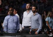 Donald Trump Jr., right, and Eric Trump, center, watch the post fight ceremony of a lightweight mixed martial arts bout between Jim Miller and Clay Guida at UFC Fight Night Saturday, Aug. 3, 2019, in Newark, N.J. Guida stopped Miller in the first round. (AP Photo/Frank Franklin II)