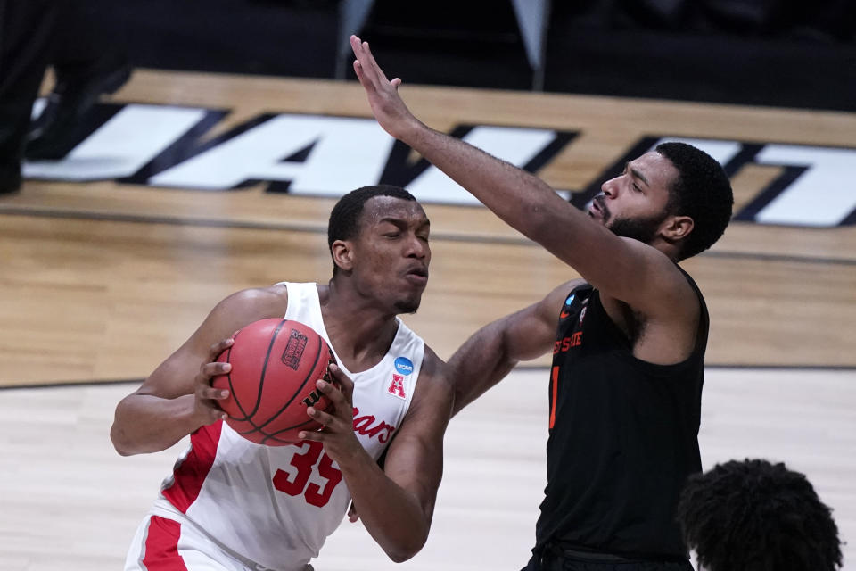 Houston forward Fabian White Jr. (35) drives on Oregon State forward Maurice Calloo, right, during the first half of an Elite 8 game in the NCAA men's college basketball tournament at Lucas Oil Stadium, Monday, March 29, 2021, in Indianapolis. (AP Photo/Michael Conroy)