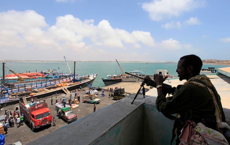 FILE PHOTO: A soldier from Somalia's Ras-Kamboni paramilitary group stands guard as he monitors activities at the sea port in lower juba regions in Kismayu