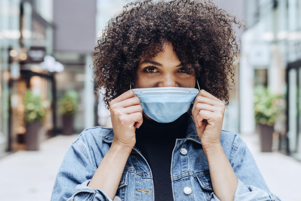 Woman smiling behind a surgical face mask