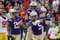 Washington's Andre Baccellia (5) celebrates his recovery of a fumble in the end zone for a touchdown with Jaxson Kirkland (51) and Aaron Fuller (2) against Southern Cal in the first half of an NCAA college football game Saturday, Sept. 28, 2019, in Seattle. (AP Photo/Elaine Thompson)