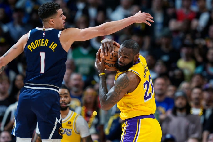 Los Angeles Lakers forward LeBron James, right, pulls in a rebound as Denver Nuggets forward <a class="link " href="https://sports.yahoo.com/nba/players/6025/" data-i13n="sec:content-canvas;subsec:anchor_text;elm:context_link" data-ylk="slk:Michael Porter Jr.;sec:content-canvas;subsec:anchor_text;elm:context_link;itc:0">Michael Porter Jr.</a> (1) defends in the second half of Game 5 of an NBA basketball first-round playoff series Monday, April 29, 2024, in Denver. (AP Photo/David Zalubowski)