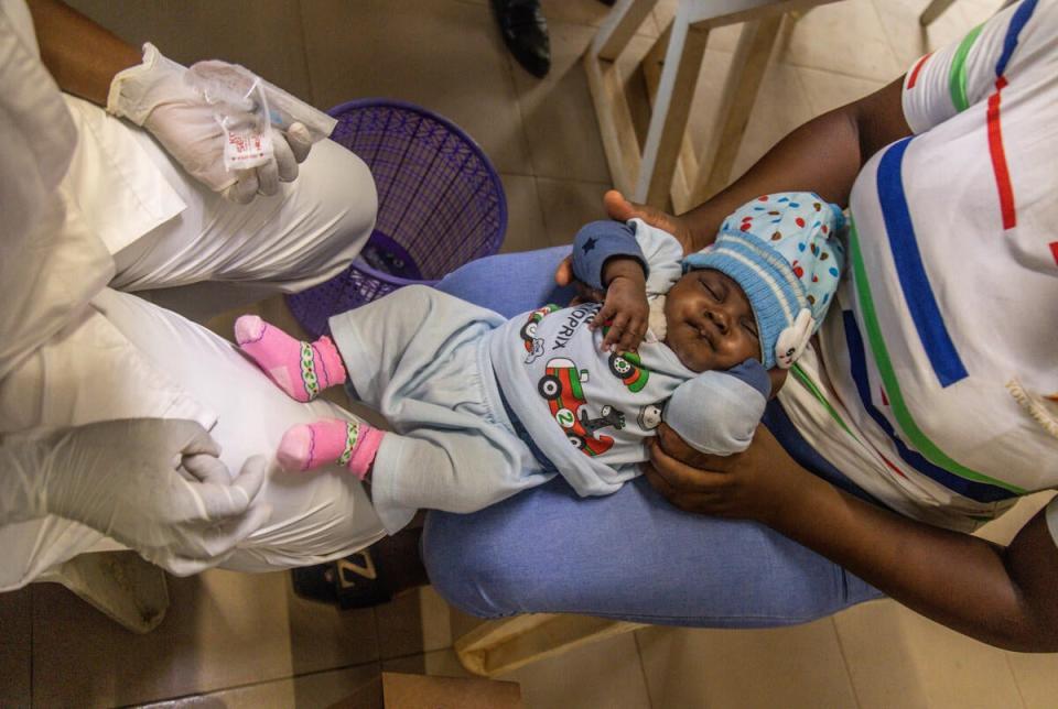 Olatunji administers a vaccine to a child (Yagazie Emnezi/Save The Children)