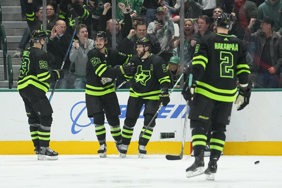 Dallas Stars players, from left, Esa Lindell, Mason Marchment, Tyler Seguin and Jani Hakanpaa react after a goal by Seguin during the second period of an NHL hockey game against the Colorado Avalanche, Saturday, Nov. 18, 2023, in Dallas. (AP Photo/Julio Cortez)