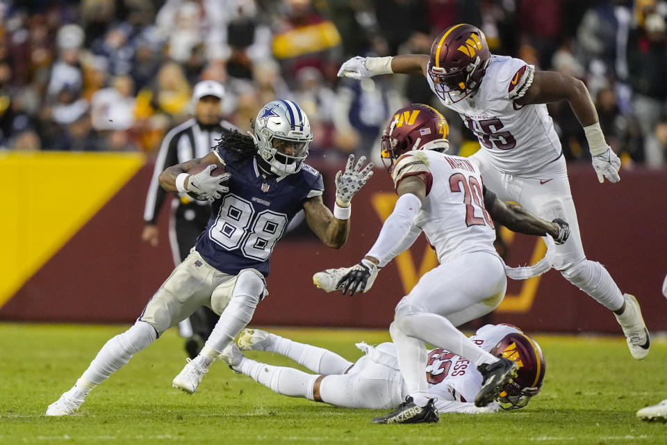 Dallas Cowboys wide receiver CeeDee Lamb (88) goes up against from l-r., Washington Commanders safety Terrell Burgess (32), safety Jartavius Martin (20), and defensive end KJ Henry (55), during the first half of an NFL football game, Sunday, Jan. 7, 2024, in Landover, Md. (AP Photo/Mark Schiefelbein)