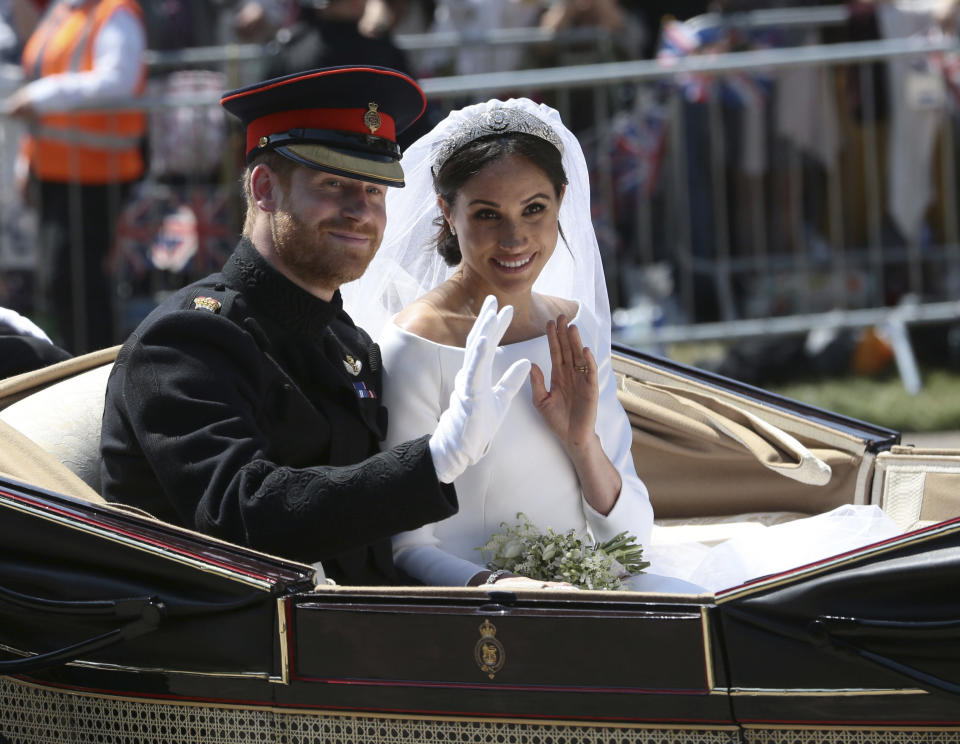 En esta foto del 19 de mayo de 2018, el príncipe Enrique de Inglaterra y Meghan Markle saludan desde una carroza tras la ceremonia de su boda en la Capilla de San Jorge, en el Castillo de Windsor, en Windsor, Inglaterra. (Aaron Chown/pool photo via AP, file)