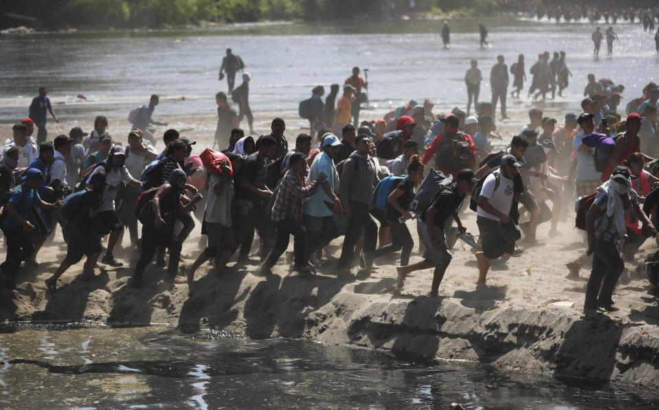 Central American migrants run on the Mexican side of the bank of the Suchiate River after crossing from Guatemala, near Ciudad Hidalgo, Mexico, Monday, Jan. 20, 2020. More than a thousand Central American migrants hoping to reach United States marooned in Guatemala are walking en masse across a river leading to Mexico in an attempt to convince authorities there to allow them passage through the country. (AP Photo/Marco Ugarte)