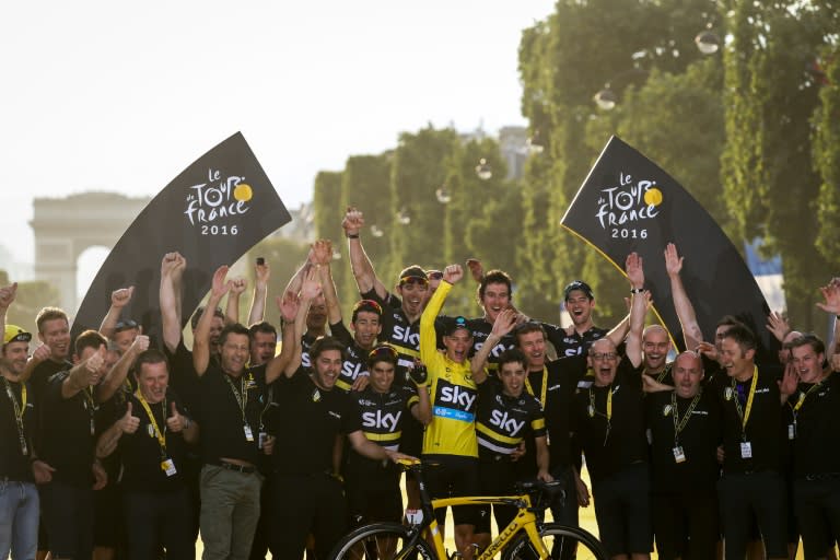 Chris Froome (C) celebrates with his teammates and staff members of Great Britain's Sky cycling team on the Champs-Elysees avenue in Paris on July 24, 2016