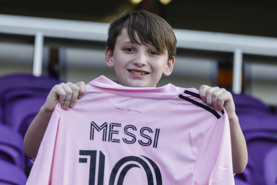 Evan Grover, de 12 años, sostiene una camiseta de Lionel Messi del Inter Miami previo al partido de la MLS contra Orlando City, el domingo 24 de septiembre de 2023, en Orlando. (AP Foto/Kevin Kolczynski)