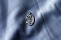 A religious medal, which was found sewn into the waistband of Charlie Armstrong's trousers when his remains were discovered, is displayed in the family home in Crossmaglen, County Armagh November 4, 2014. REUTERS/Cathal McNaughton