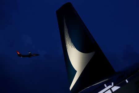 A plane flies behind a new Cathay Pacific Airways Airbus A350 after being received by the airline at Hong Kong Airport May 30, 2016. REUTERS/Bobby Yip/Files