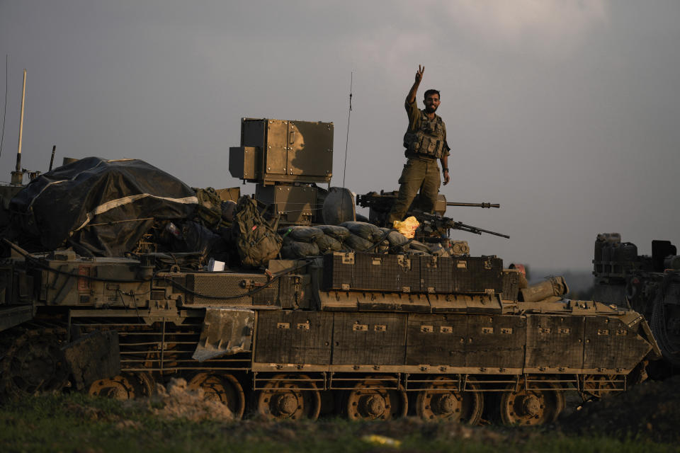 An Israeli soldier flashes a V-sign from an armoured personnel carrier (APC) near the Israeli-Gaza border, in southern Israel, Monday, Dec. 25, 2023. The army is battling Palestinian militants across Gaza in the war ignited by Hamas' Oct. 7 attack into Israel. (AP Photo/Leo Correa)