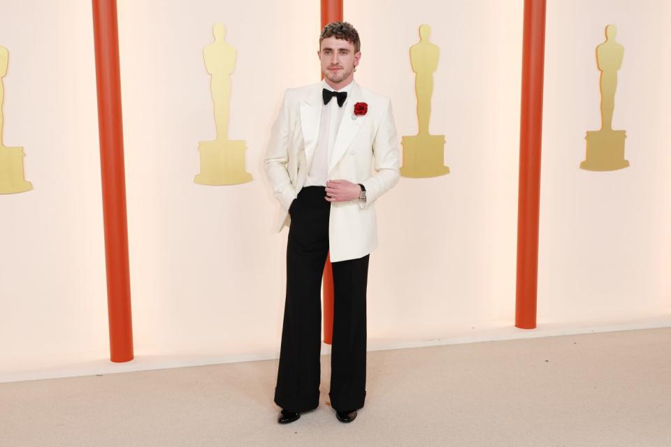 Paul Mescal in a long white tuxedo jacket with flared black pants.