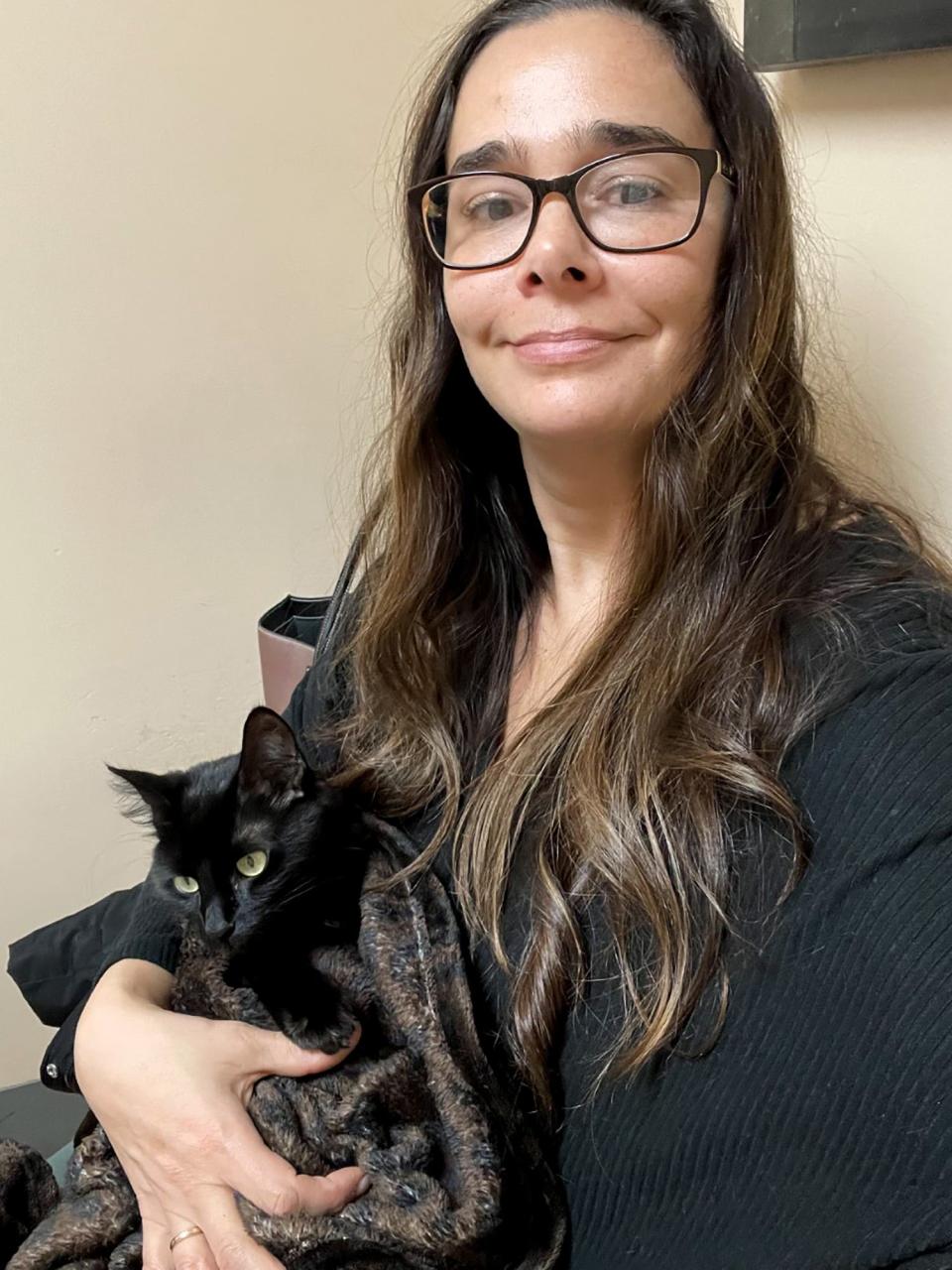 Jenay Chartier holds Freezy, a cat she found with three of her paws frozen in the snow. This was at Freezy's visit to the vet following her rescue.