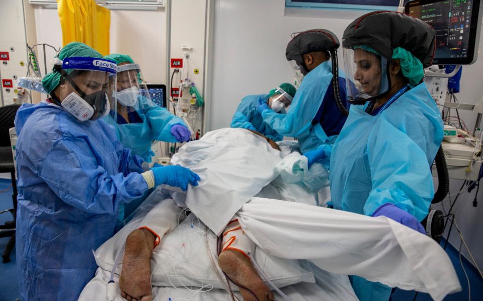 Staff in the unit 'proning' a patient. Lying face down helps oxygenate the blood which in turn assists with combatting respiratory distress. - Heathcliff O'Malley for the Telegraph