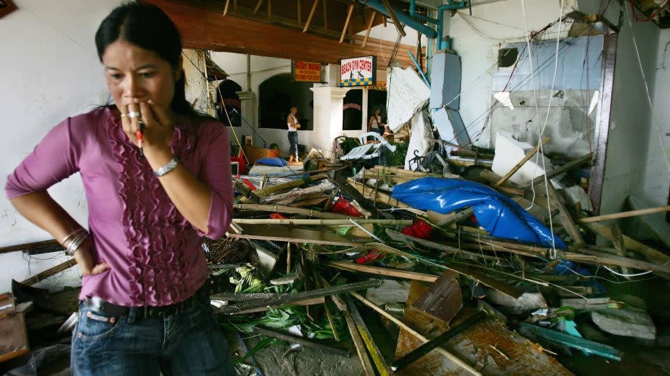 A Thai woman walks by the devastation at a hotel along Patong Beach, one of the worst tsunami-hit provinces, on December 27, 2004, in Phuket, Thailand. The Boxing Day tsunami triggered by a massive underwater quake in the Indian Ocean killed at least 225,000 people. - Paula Bronstein/Getty Images