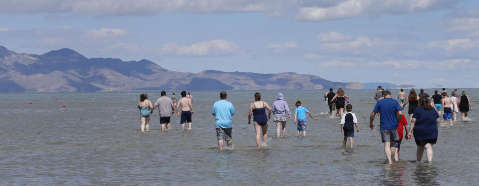 People enter the Great Salt Lake during a gathering that fell short of making it into the record books Saturday, June 8, 2019, near Magna, Utah. Utah park officials invited people to a beach on the lake's south end in an attempt to set the world record for the largest number of people floating together, unassisted, in a line at one time. Utah State Parks manager Jim Wells said only about 300 people showed up for the event. According to the Guinness World Records website , Argentina holds the current record after 1,941 people successfully floated together on the surface of Lago Epecuén de Carhué in 2017. (AP Photo/Rick Bowmer)