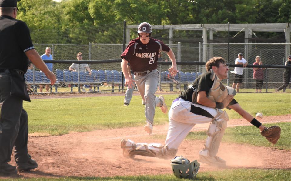 Oriskany Redskin Noah Narolis (22) races toward home plate as a throw skips away from West Canada Valley catcher Josh Grabowski during Saturday's Section III Class D semifinal at Murnane Field.