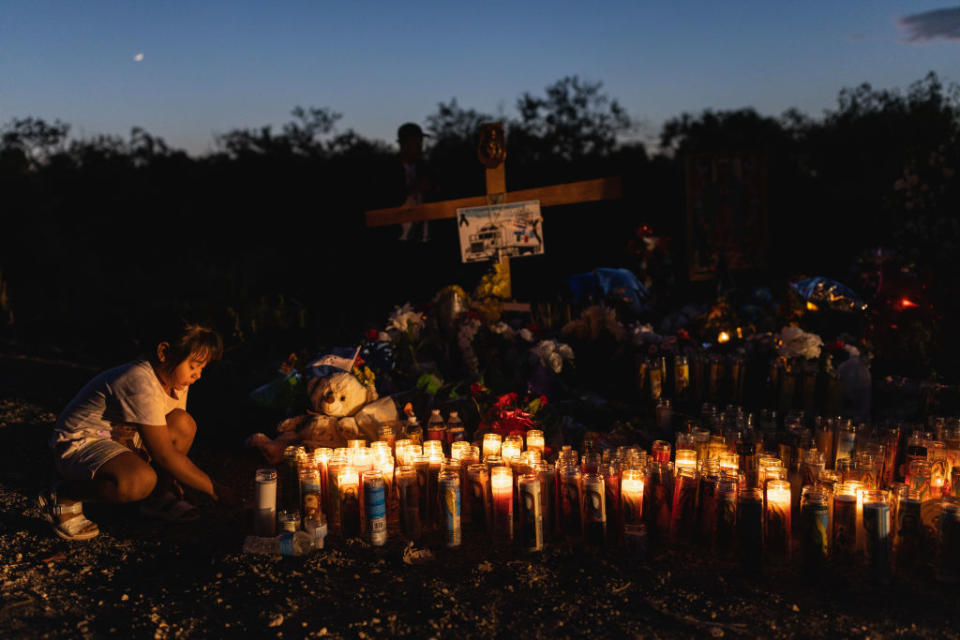 People gather at a makeshift memorial which has been erected at the site where 53 migrants died on June 30, 2022 in San Antonio, Texas.<span class="copyright">Jordan Vonderhaar—Getty Images</span>
