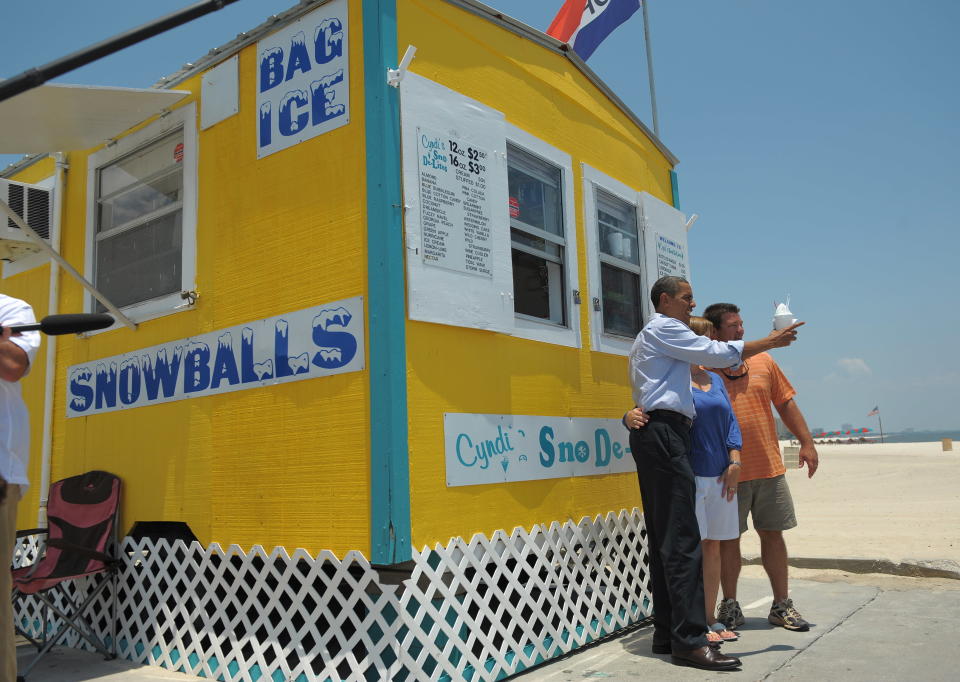 President Barack Obama (left) poses with a local while enjoying a snow cone following a roundtable discussion with local residents on June 14, 2010, in Gulfport, Mississippi. Obama implored Americans to visit the beaches of the southern Gulf coast, as the lucrative tourism industry fears a hammering over the BP oil disaster.