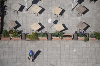 A man walks past the closed outdoor area of a restaurant in Frankfurt, Germany, Thursday, May 13, 2021. In Frankfurt, outdoor restaurants are not yet allowed to open. (Sebastian Gollnow/dpa via AP)