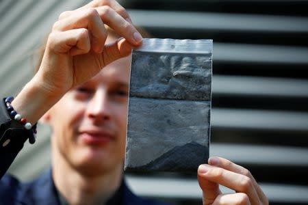 Dutch artist and innovator Daan Roosegaarde holds smog particles collected by the Smog Free Tower, the world's largest smog vacuum cleaner as the artist presents his The Smog Free Project at D-751 art zone in Beijing September 29, 2016. REUTERS/Damir Sagolj