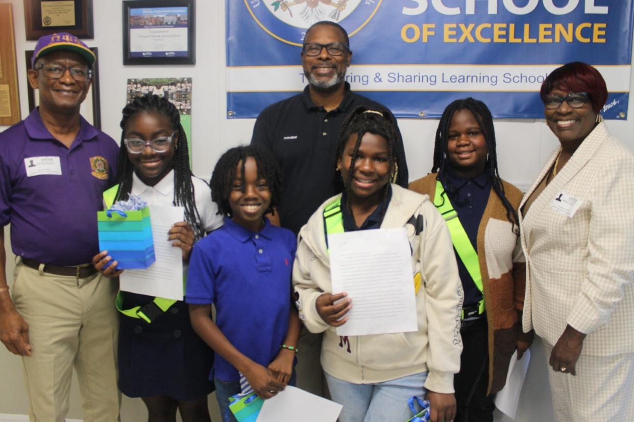 Fifth-graders at Caring and Sharing Learning School were honored for writing essays about gun violence in the community,. The students from left are Aulani Newton, Barrington Carey, Deanna Moore and Zendaya Stephens. They are flanked by essay contest organizers from far left, Michael Perkins, back center, Curtis Peterson, principal of Caring and Sharing Learning School and far right, the Rev. Dr. Marie Herring, pastor of Dayspring Baptist Church.
(Credit: Photo by Voleer Thomas/For The Guardian)