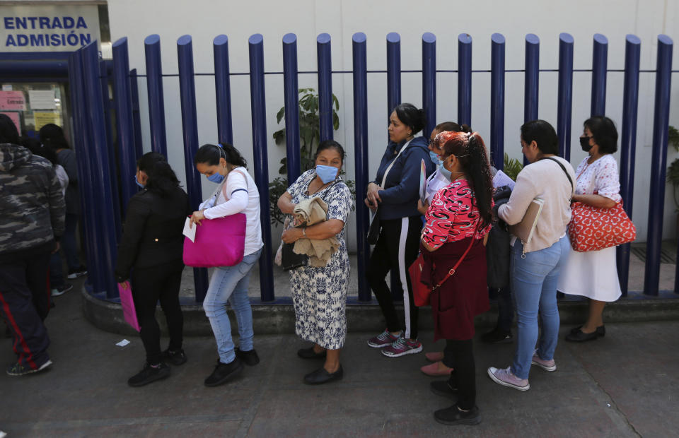 Women wear masks over their mouths as a precaution against the spread of the new coronavirus as they wait to enter as visitors the national hospital that specializes in respiratory diseases, the INER, in Mexico City, Friday, Feb. 28, 2020. Mexico's assistant health secretary announced Friday that the country now has confirmed cases of the COVID-19 virus. (AP Photo/Fernando Llano)