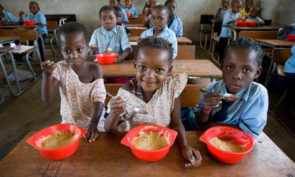 Students eat lunch in a classroom at Ceramica primary school in Beira, Sofala, Mozambique