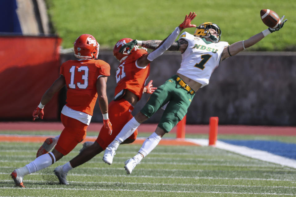 FILE - North Dakota State wide receiver Christian Watson (1) leaps past Sam Houston State defensive backs Isaiah Downes (13) and Kameryn Alexander (21) but cannot come down with the reception during the fourth quarter of a quarterfinal in the NCAA college FCS football playoffs May 2, 2021, in Huntsville, Texas. Watson was selected by the Green Bay Packers in the second round of the NFL draft Friday, April 29. (Brett Coomer/Houston Chronicle via AP, File)